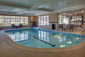 桑兹顿里士满机场希尔顿恒庭酒店的大楼内带桌椅的大型游泳池