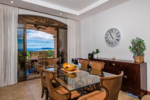 普拉卡海尔Jobo 8 Luxury Apartment - Reserva Conchal的一间带桌椅和时钟的用餐室
