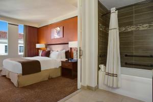 圣安东尼奥艾米丽摩根 - 希尔顿逸林酒店的酒店客房配有一张床和淋浴