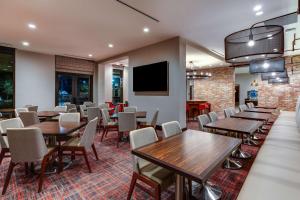 萨凡纳萨凡纳历史区霍姆/滨河伍德套房酒店的餐厅设有桌椅和平面电视。