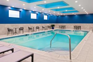 索尔兹伯里索尔兹伯里汉普顿酒店的一座配有桌椅的酒店游泳池