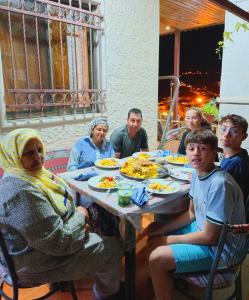 瓦迪穆萨Petra downtown house的一群坐在桌子旁吃食物的人