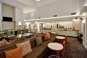 米德瓦尔盐湖城米德维勒/桑迪希尔顿惠庭套房酒店的酒店大堂设有沙发和桌子