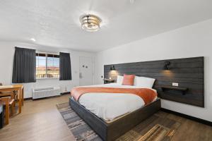 托里布罗肯马刺酒店及牛排餐厅的一间卧室配有一张大床和一张书桌