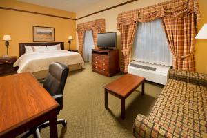 斯蒂尔沃特斯蒂尔沃特汉普顿套房酒店的酒店客房配有床、沙发和电视。