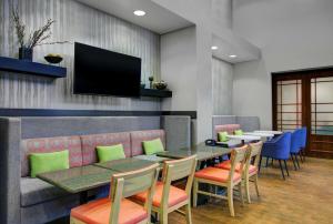 东叙拉古Hampton Inn & Suites by Hilton Syracuse Dewitt的餐厅设有桌椅和平面电视。