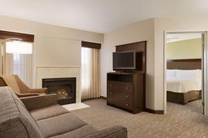 莫米托莱多 - 莫米希尔顿惠庭套房酒店的带沙发、电视和床的客厅