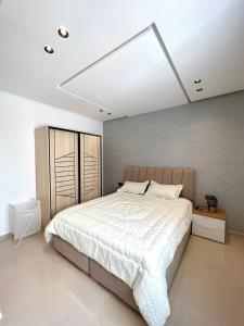 盖尼特拉Oasis Mehdia vue sur mer的一间卧室配有一张带白色床罩的大床