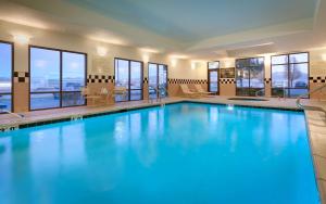特里蒙顿特莱蒙顿希尔顿恒庭酒店的一座拥有蓝色水的游泳池,位于酒店,设有窗户