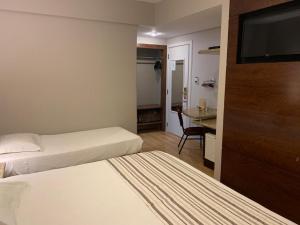 隆德里纳波旁隆德里纳商务酒店的酒店客房设有两张床和一台平面电视。