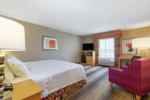 特克萨卡纳特克萨卡纳汉普顿酒店的配有一张床和一把椅子的酒店客房