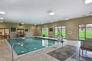 New Hartford新哈特福德/尤蒂卡汉普顿套房酒店的一个带桌椅的房间的游泳池