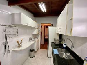 乌巴图巴Villa do Aconchego的厨房配有白色橱柜和水槽