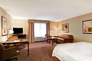萨德伯里安大略萨德伯里汉普顿旅馆的酒店客房配有床、书桌和沙发。