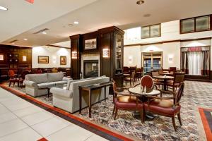 多伦多多伦多机场企业中心希尔顿惠庭套房酒店的一个带桌椅的大堂和一间客厅