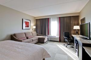 马卡姆多伦多万锦希尔顿汉普顿套房酒店的酒店客房配有床、沙发和电视。