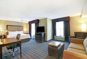 坎布里奇安大略省剑桥-滑铁卢希尔顿惠庭套房酒店的酒店客房配有一张床、一张书桌和沙发。