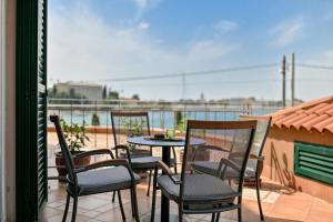 扎达尔Villa Hresc M的阳台的天井配有四把椅子和一张桌子