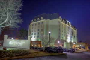 亚特兰大Doubletree Suites by Hilton at The Battery Atlanta的停车场内停放汽车的大型建筑