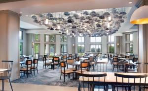 玛丽埃塔市希尔顿亚特兰大/马利耶塔酒店及会议中心的一间带桌椅和吊灯的用餐室