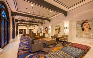 奥斯汀奥斯丁希尔顿逸林酒店的大堂设有沙发椅和墙上的绘画作品