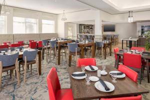 布卡拉顿博卡拉顿希尔顿花园酒店的餐厅设有木桌和红色椅子