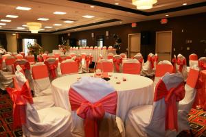 特鲁斯维尔伯明翰/特鲁斯维尔希尔顿花园酒店的宴会厅设有白色的桌子和红色的弓