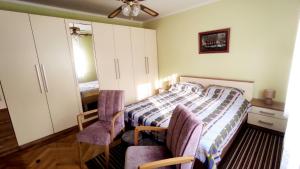 贾科沃Kuća za odmor Proljeće的一间卧室配有一张床和两把椅子