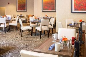 米尔福德DoubleTree by Hilton Boston-Milford的用餐室配有桌子和白色椅子