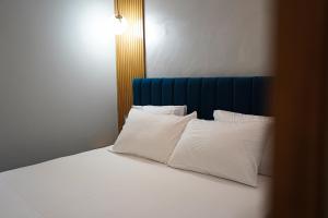 格勒姆Hotel DelMar的一张带白色枕头和蓝色床头板的床