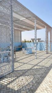 阿夏尔奇亚Al Saad chalet的天井上配有桌椅的金属凉亭