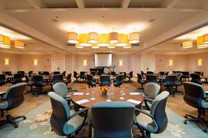 斯科基芝加哥-北海岸会议中心枫林希尔顿酒店的一间会议室,配有大桌子和椅子