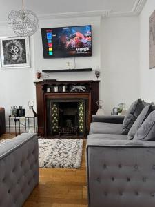 曼彻斯特Amazing Entire 4 Bedroom Home的客厅设有壁炉和墙上的电视