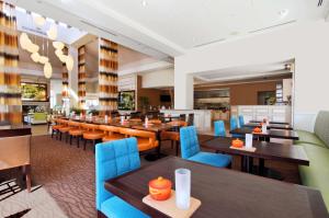 圣查尔斯圣查尔斯希尔顿花园旅馆的餐厅设有木桌和蓝色椅子