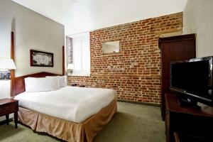 查尔斯顿查尔斯顿大使馆套房酒店 - 历史区的酒店客房,设有床铺和砖墙