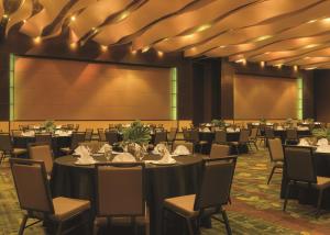 锡达拉皮兹锡达拉皮兹会议中心希尔顿逸林酒店的一间会议室,配有桌椅和投影屏幕