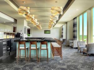 锡达拉皮兹锡达拉皮兹会议中心希尔顿逸林酒店的大堂设有带凳子和窗户的酒吧