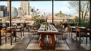 洛杉矶Downtown Los Angeles Proper Hotel, a Member of Design Hotels的一间带桌椅的市景餐厅