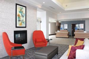科罗拉多斯普林斯科罗拉多斯普林斯机场希尔顿花园酒店的客厅配有红色椅子和壁炉
