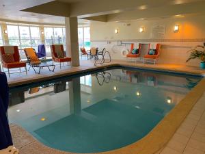 科罗拉多斯普林斯科罗拉多斯普林斯机场希尔顿花园酒店的一座配有桌椅的酒店游泳池