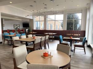 科罗拉多斯普林斯科罗拉多斯普林斯机场希尔顿花园酒店的用餐室设有桌椅和窗户。