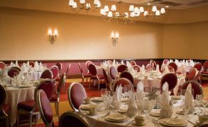 希布伦辛辛那提机场希尔顿逸林酒店的一间设有桌椅和白色桌布的房间