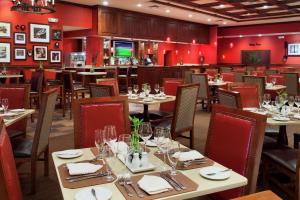 希布伦辛辛那提机场希尔顿逸林酒店的一间带桌椅的餐厅和一间酒吧