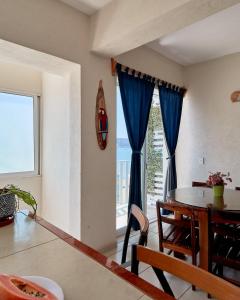 圣帕特里西奥梅拉克Bungalows Las Hamacas的一间带桌子和大窗户的用餐室