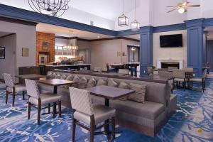 路易斯维尔达拉斯路易斯维尔希尔顿惠庭套房酒店的一间带桌椅和壁炉的餐厅