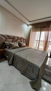 阿加迪尔Appartement Anir的一间卧室设有一张大床和一个大窗户