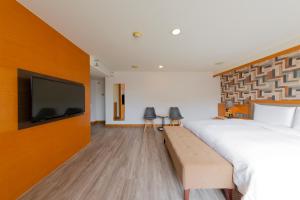 高雄西子湾大饭店的一间卧室配有一张大床和一台平面电视