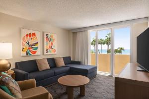 迪尔菲尔德海滩Embassy Suites by Hilton Deerfield Beach Resort & Spa的带沙发的客厅和享有海滩美景的客房。