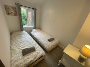 麦克尔斯菲尔德Tucked away house in Macclesfield的一间卧室设有两张床和窗户。