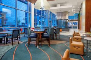 丹佛汉普顿套房酒店及丹佛市区会议中心的餐厅设有桌椅和窗户。